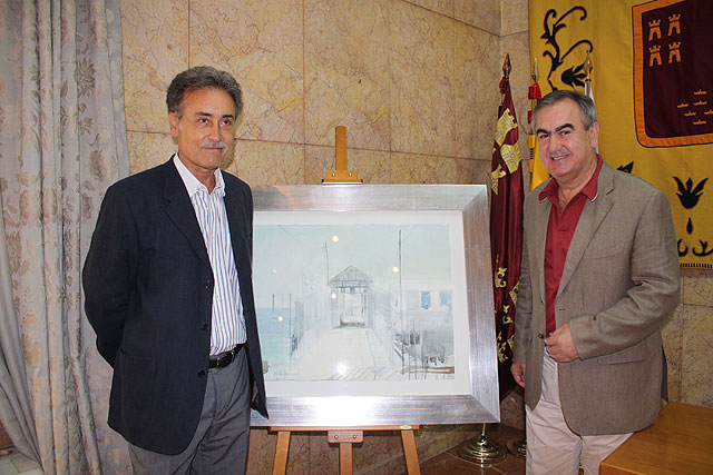 El delegado del Gobierno, Rafael González Tovar, y el pintor Pedro Cano, con el original del cartel de anunciador de la Semana
